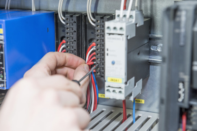 Close-up of electrician screwing cable in distribution fusebox, Munich, Bavaria, Germany