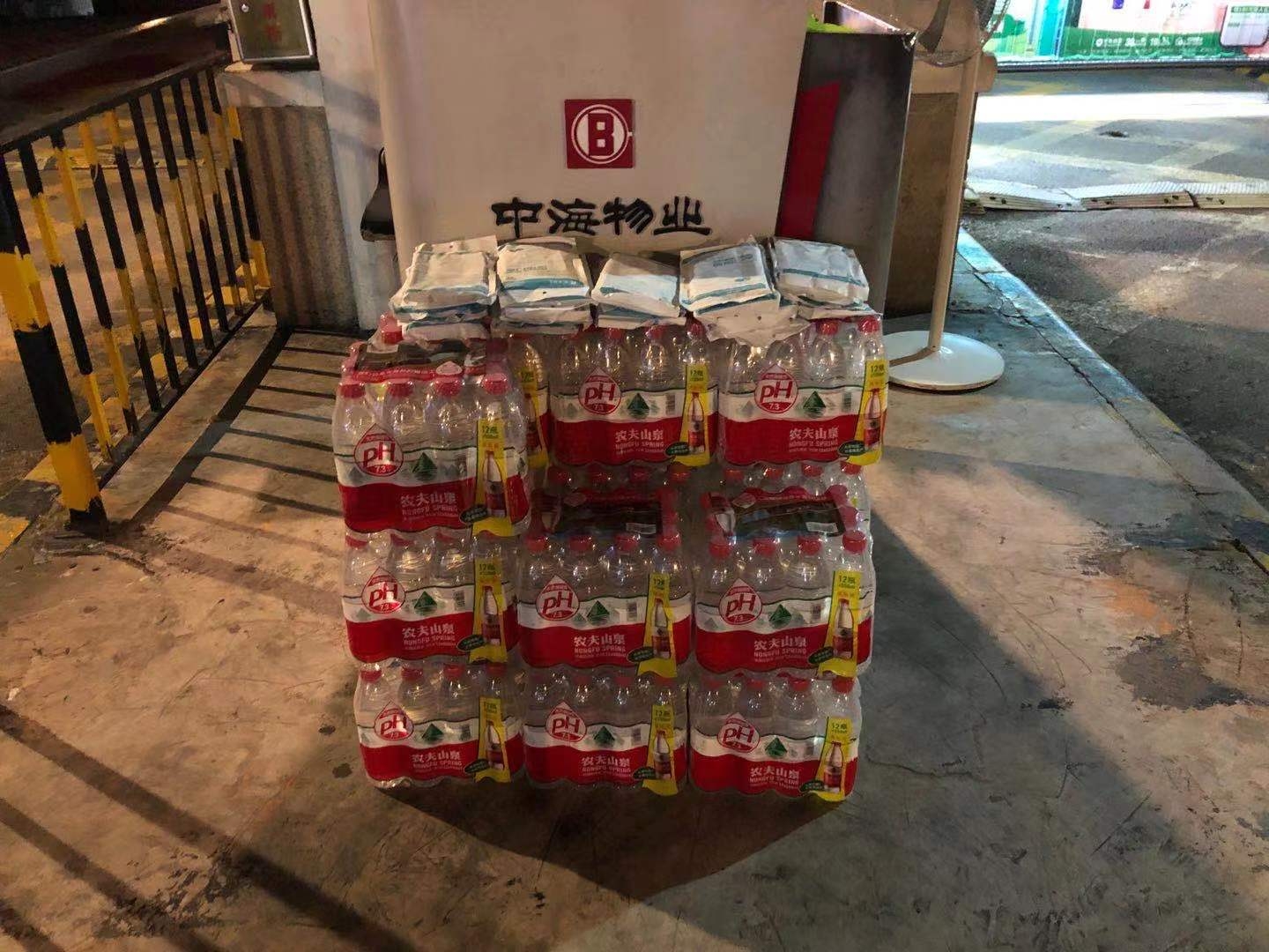 7月28日晚,中海名城项目门岗处堆放着十几袋口罩和十几箱矿泉水