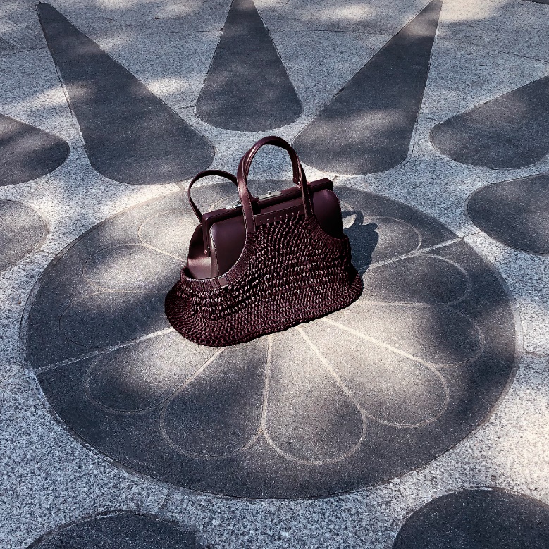 A purse on a tile floorDescription automatically generated with medium confidence